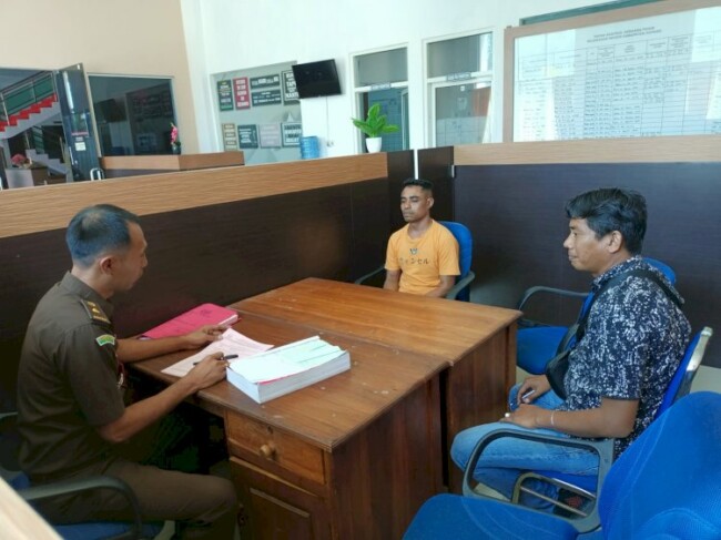 Foto: Tersangka pembakaran rumah, Nardiyanto Reo, ketika diserahkan oleh penyidik Satreskrim Polres Kupang ke Jaksa Penuntut Umum (JPU) Pengadilan Negeri Oelamasi. 
