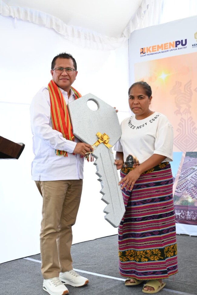 Foto: Bupati Kupang, Yosef Lede, S.H., saat menyerahkan kunci rumah secara simbolis kepada salah satu penerima. 