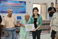 Foto: Penyerahan BLT Dana Desa kepada penerima oleh Camat Kupang Barat, Villy Nakamnanu, S.STP., di aula kantor Desa Oenaek, Jumat(08/05)
