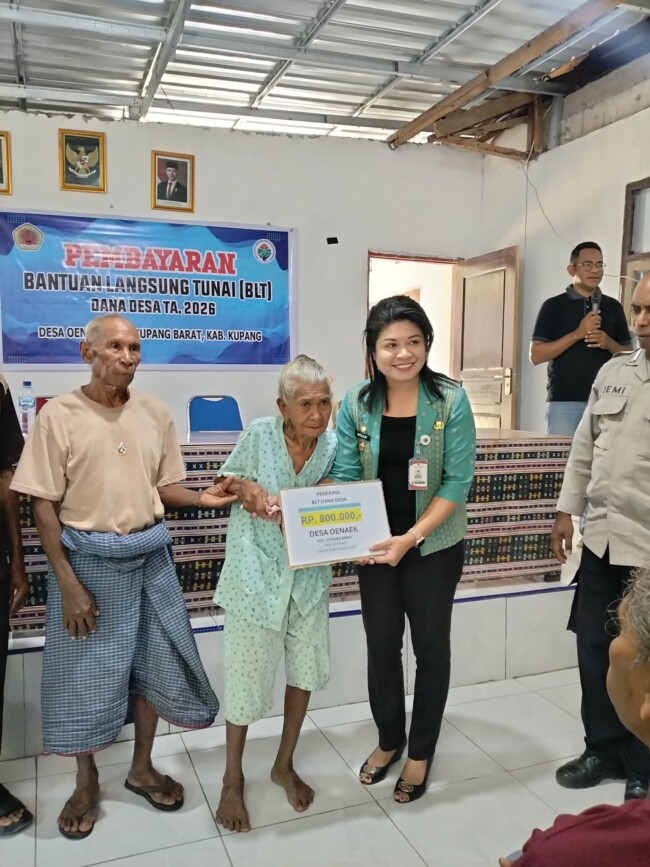 Foto: Penyerahan BLT Dana Desa kepada penerima oleh Camat Kupang Barat, Villy Nakamnanu, S.STP., di aula kantor Desa Oenaek, Jumat(08/05)