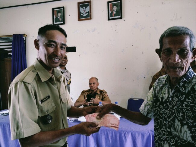 Foto: Kepala Desa Sumlili, Yusael Ndun (kiri) saat menyerahkan BLT Dana Desa kepada penerima 