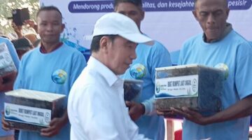 Foto: Jokowi menyerahkan bantuan bibit rumput laut secara simbolis kepada perwakilan petani rumput laut.