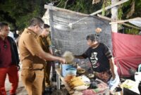 Foto: Bupati Kupang, Yosef Lede,SH., berkesempatan menikmati jagung bakar di stan UMKM, lapangan Voli Camplong
